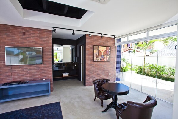 A modern living room with a TV, a coffee table, and a seating area.