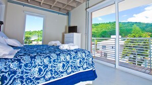 A bedroom with a large bed, a dresser, and a balcony with a view of greenery. - FL002 2 Bedroom Apartment By Senstay (Florianópolis)