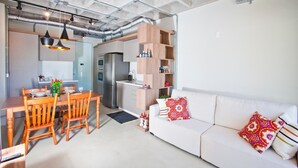 A modern kitchen with a built-in oven and a dining area with wooden chairs and a table. - FL002 2 Bedroom Apartment By Senstay (Florianópolis)