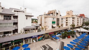 A multi-story building with a ground-level commercial area featuring a pharmacy, a bank, and a café.