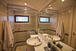 Un bagno con due lavandini, uno specchio grande e una finestra.