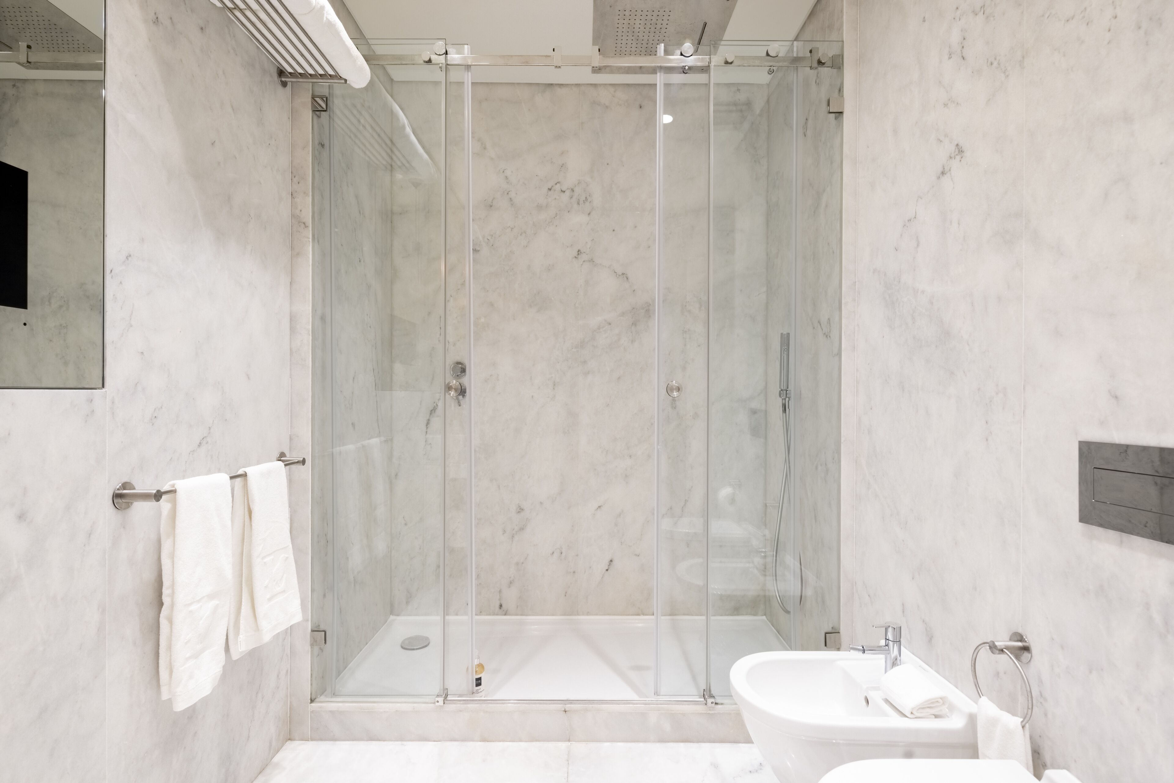 Een moderne badkamer met een douchecabine, een bad en een wastafel.