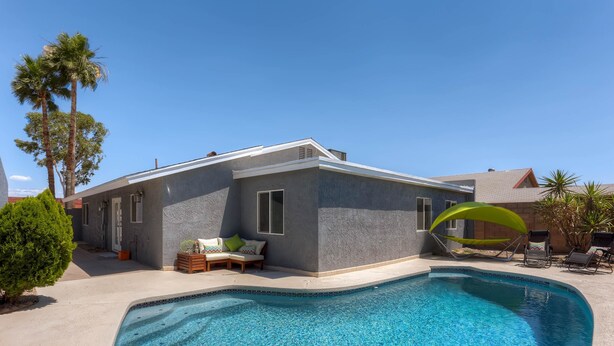 A modern house with a swimming pool, a patio with lounge chairs, and a small garden area. - PX032 4 Bedroom Holiday home By Senstay (Scottsdale)