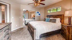 A bedroom with a wooden bed, a ceiling fan, a window with a view, and a dresser. - PX033 1 Bedroom Apartment By Senstay (Phoenix)