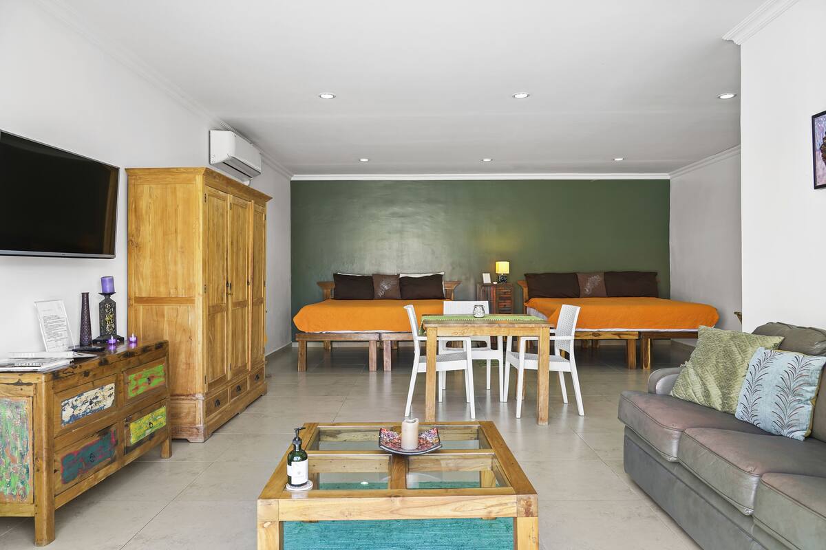 Una sala de estar moderna con un conjunto de sofás, una mesa de centro y un televisor montado en la pared.