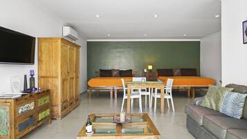 A modern living room with a sofa set, a coffee table, and a TV mounted on the wall.