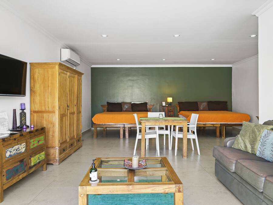 A modern living room with a sofa set, a coffee table, and a TV mounted on the wall.