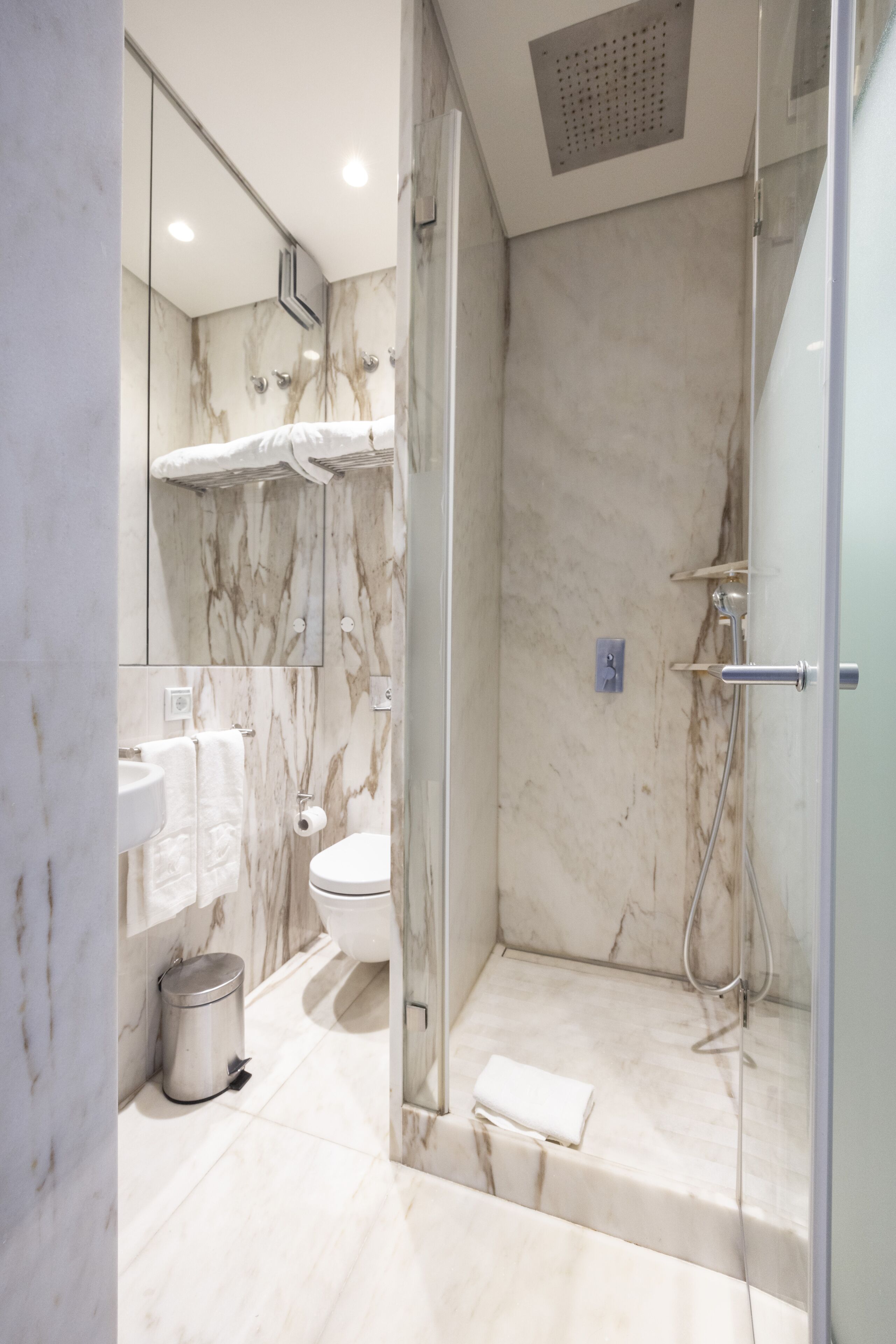Ein modernes Badezimmer mit einer gläsernen Duschkabine, einer Toilette und einem Waschbecken.