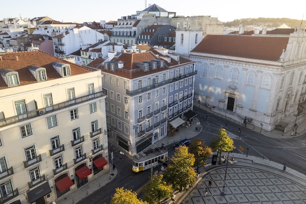 A historic European cityscape with a prominent building featuring a classical facade and a tiled roof.