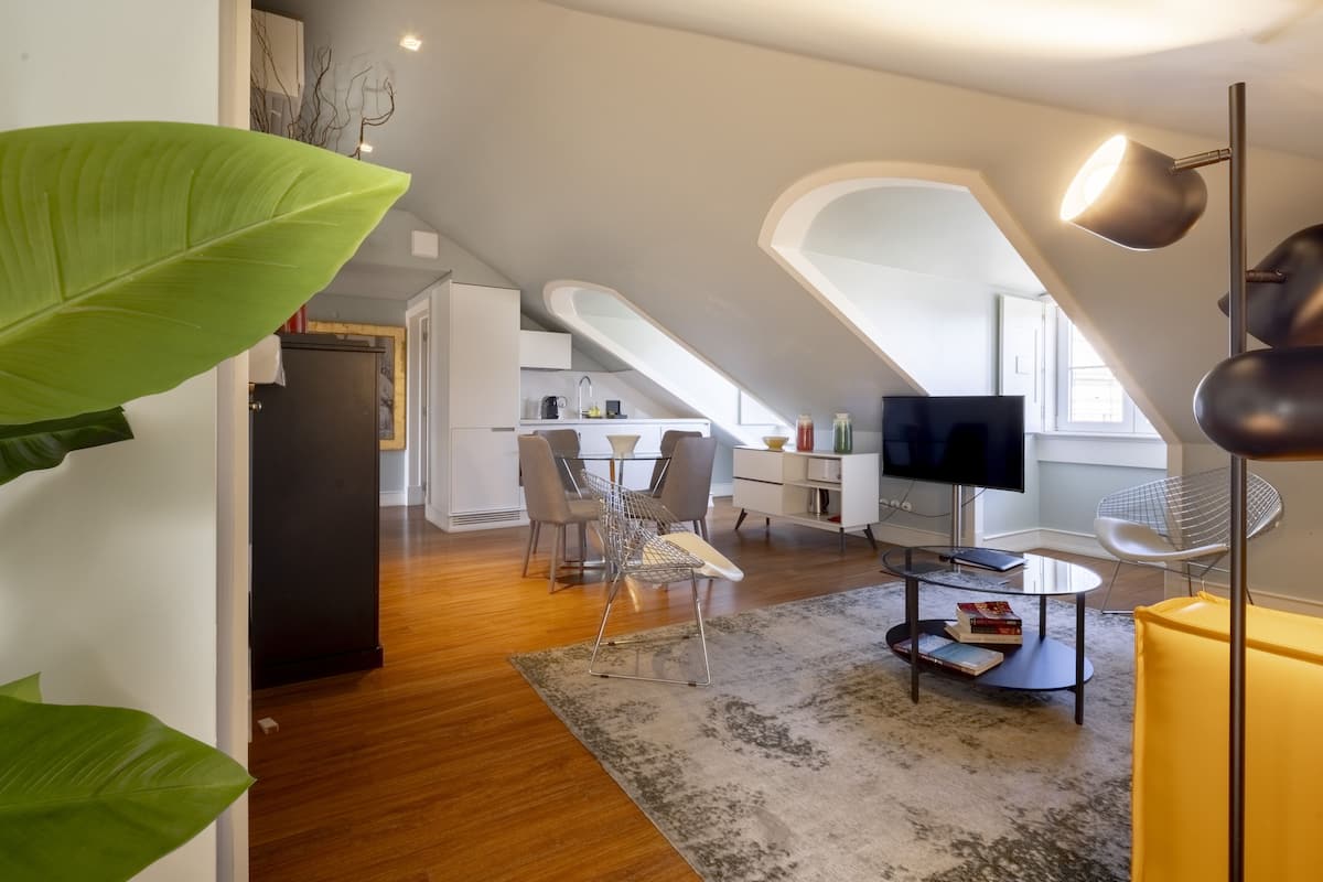 A modern loft apartment with a dining area, kitchen, and living space.