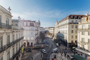 Une vue de rue avec des immeubles, un tramway et une zone piétonne.