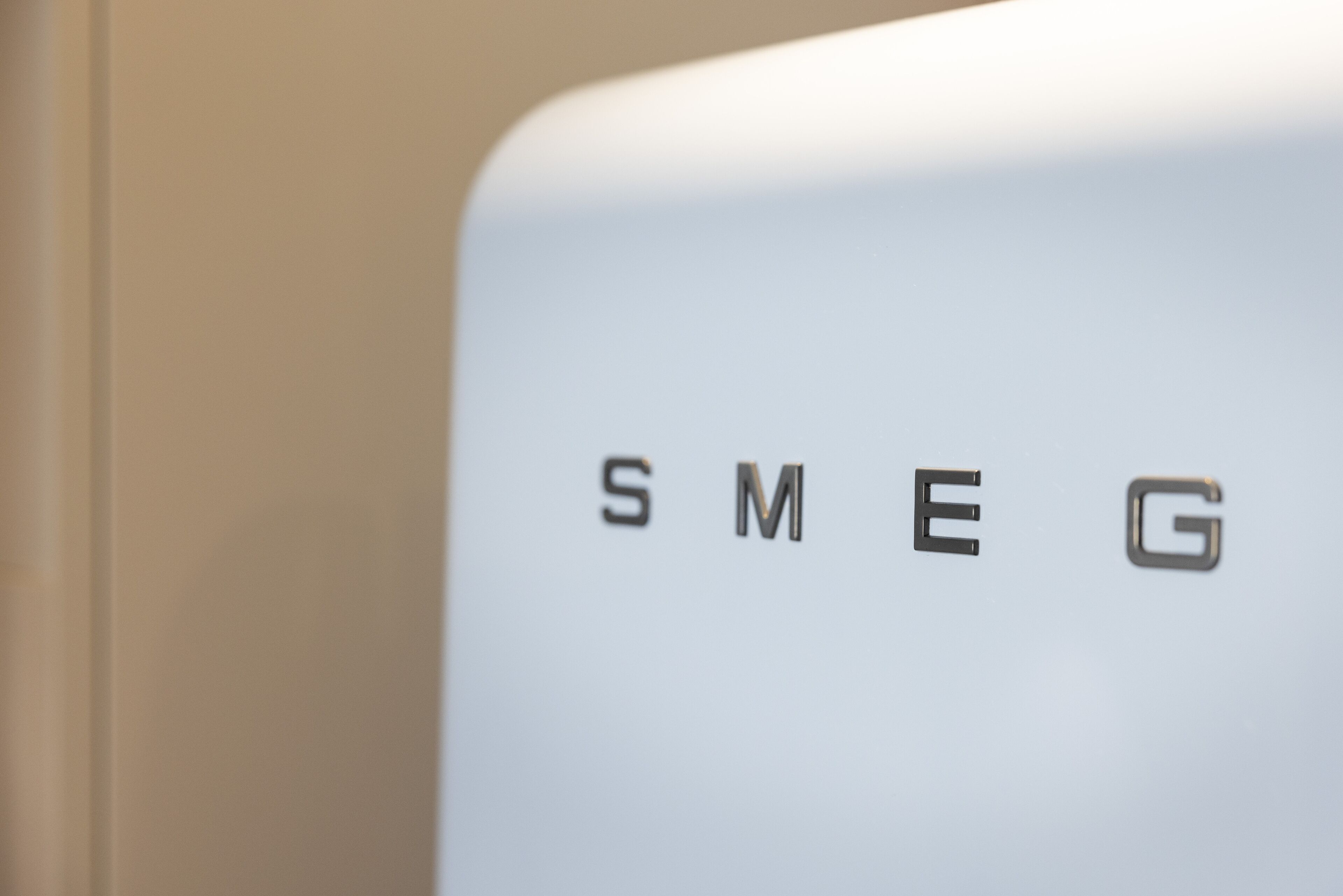 Un primo piano di un oggetto bianco con le lettere "SMEG" in rilievo.