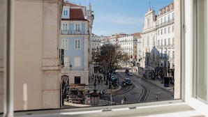 A street view with buildings, a tree, and a tram. - Chiado Square - Lisbon Best Apartments (Lisbon)