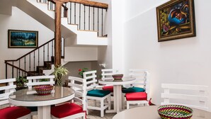 A modern interior with a staircase, white furniture, and artwork. - Hotel Casa Ecuatreasures Centro Histórico (Quito)