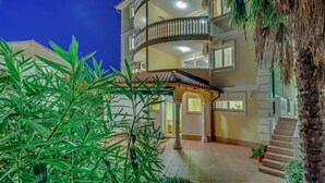 A multi-story building with balconies, a tiled entrance, and surrounding greenery. - Apartment in Croatia near Sea Beach & Pool (Crikvenica)