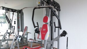 A gym with exercise equipment, a mirror, and a wooden floor. - Ibis Styles Cikarang (Cikarang)