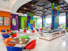Un espace repas moderne avec des chaises colorées et un comptoir de buffet.