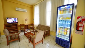 Une chambre d’hôtel équipée d’une télévision, d’un coin salon et d’un mini-réfrigérateur pour les boissons.