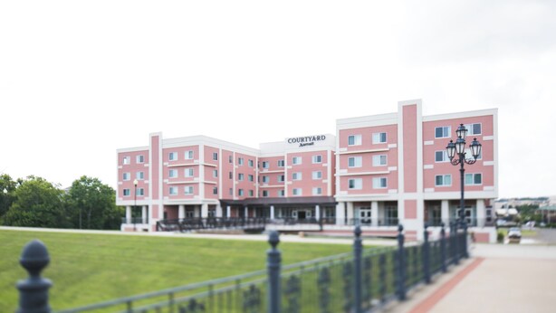 A Courtyard hotel with a red and white facade, multiple floors, and a central courtyard.