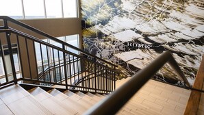 A staircase with a view of a cityscape mural, including the word "Rome". - Courtyard by Marriott Rome (Rome)
