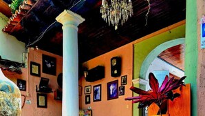 A spacious lobby with a tiled floor, a large column, and a chandelier. - Hotel San Luis (San Cristóbal de las Casas)