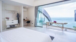 A modern bedroom with a large bed, a desk, and a view of the ocean. - Sky Dream Villa (Koh Samui)