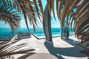 A modern pool area with clear views of the ocean, surrounded by palm trees and lounge chairs. - Sky Dream Villa (Koh Samui)
