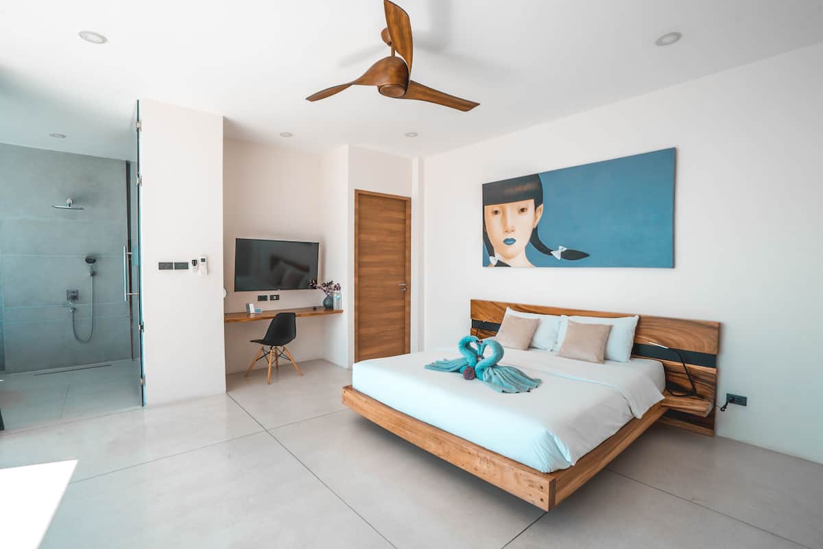Une chambre moderne avec un lit en bois, une télévision, un bureau et une douche.