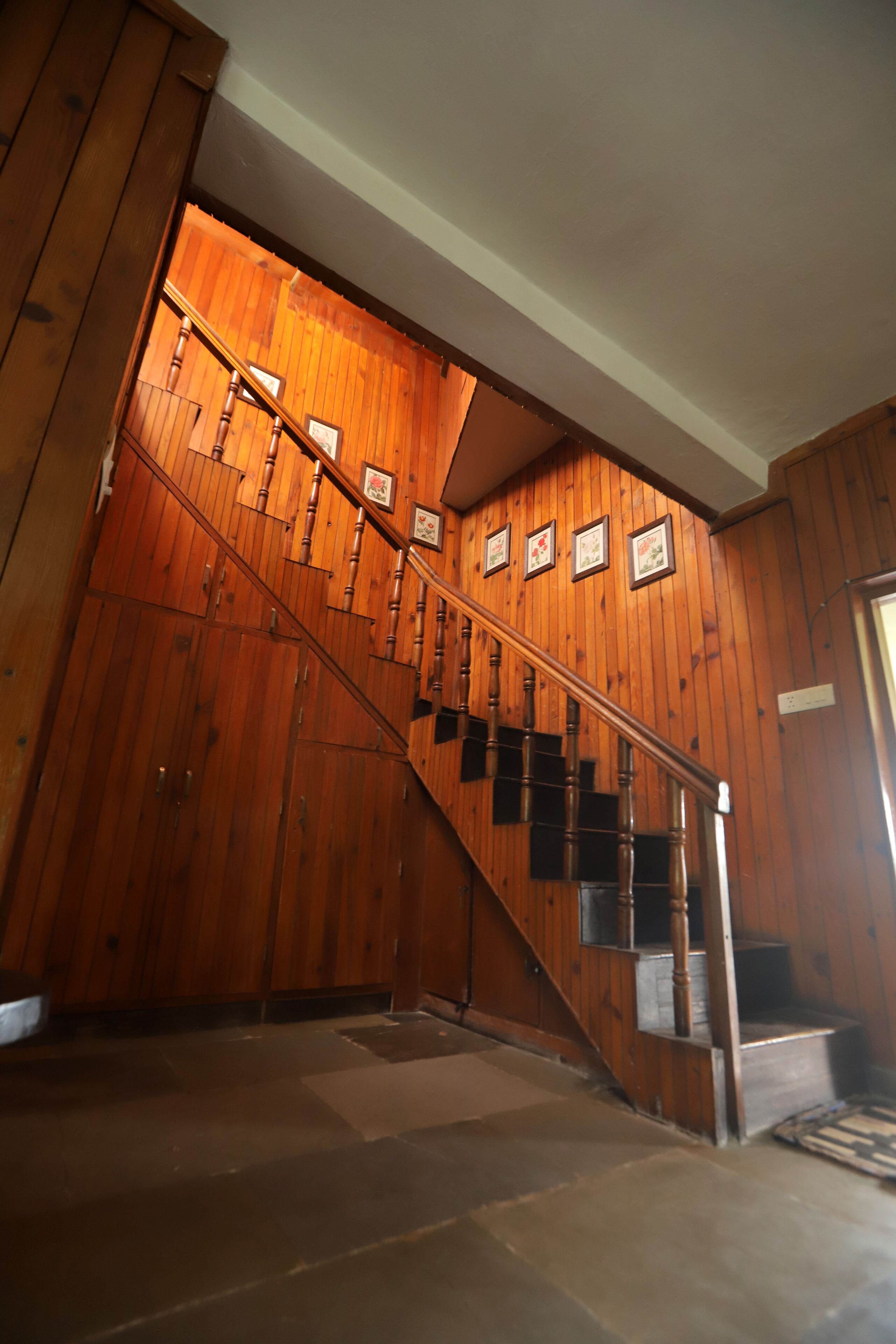 A wooden staircase with a handrail, leading to a landing with a door.