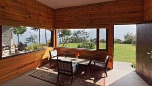 Ein Holzinterieur mit Essbereich, großen Fenstern und Blick auf einen Garten.