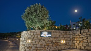 A stone wall with a sign for 'olive garden villas' and a tree. - Olive Garden Villas (Mylopotamos)