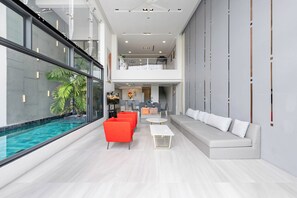 Ein modernes Interieur mit Pool, heller Beleuchtung und einem großzügigen Wohnbereich mit Sitzgelegenheiten.
