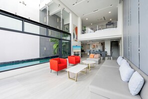 Ein großzügiger Innenbereich mit Schwimmbad, moderner Möbel und einem Balkon.