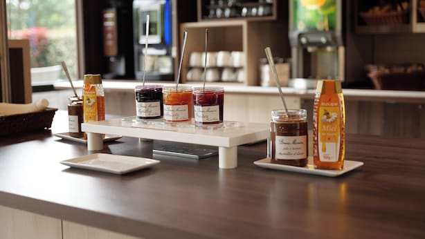 A counter with various jars of honey and a bottle of honey.