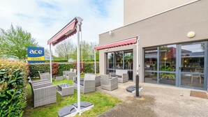 An Ace Hotel with outdoor seating and a garden area.