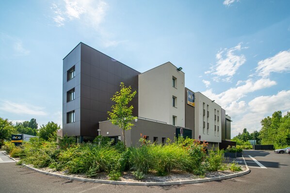 Un hôtel moderne doté d’un toit plat, d’un parking et d’un jardin aménagé.