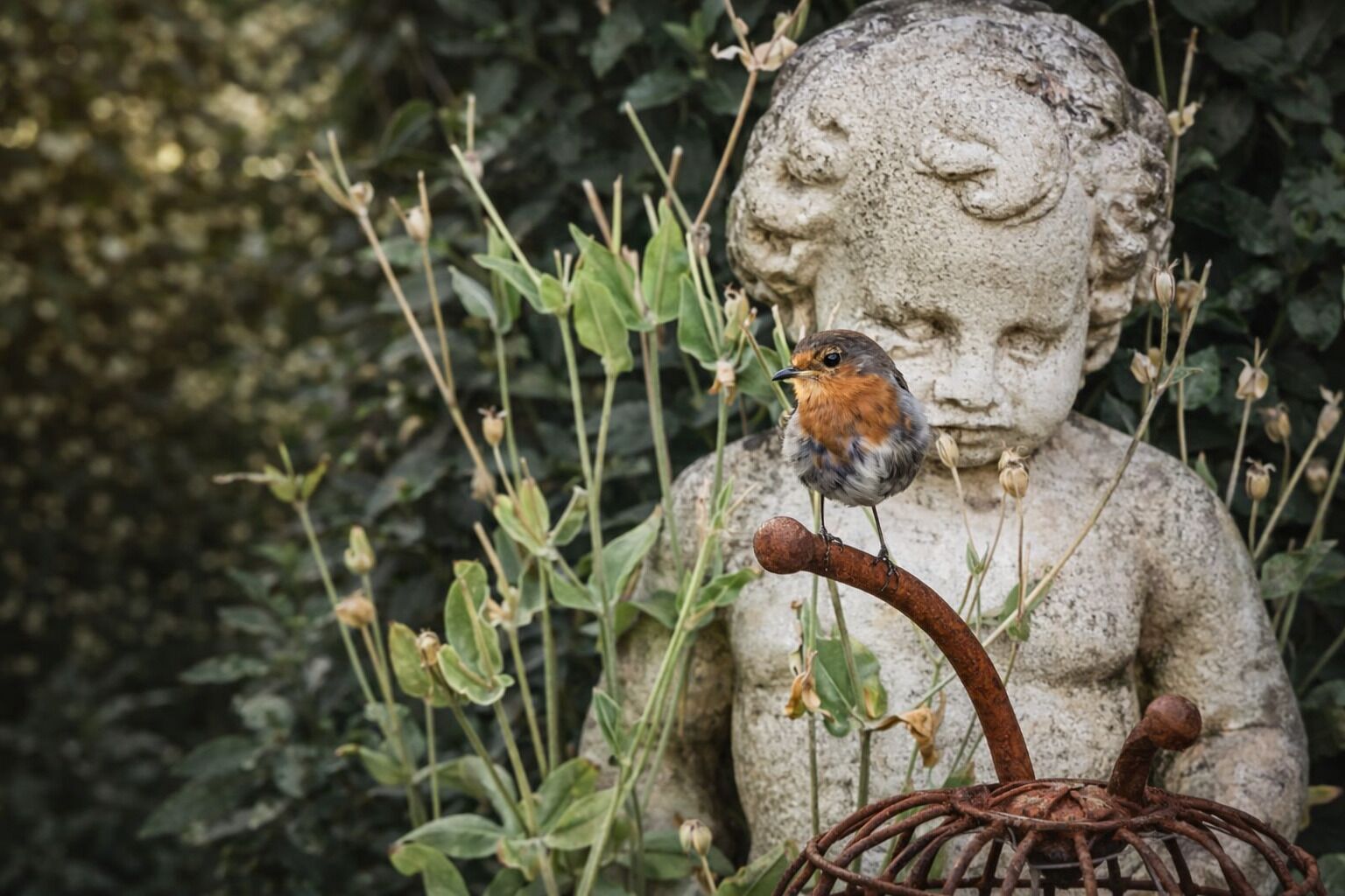 A statue with a bird perched on a branch.