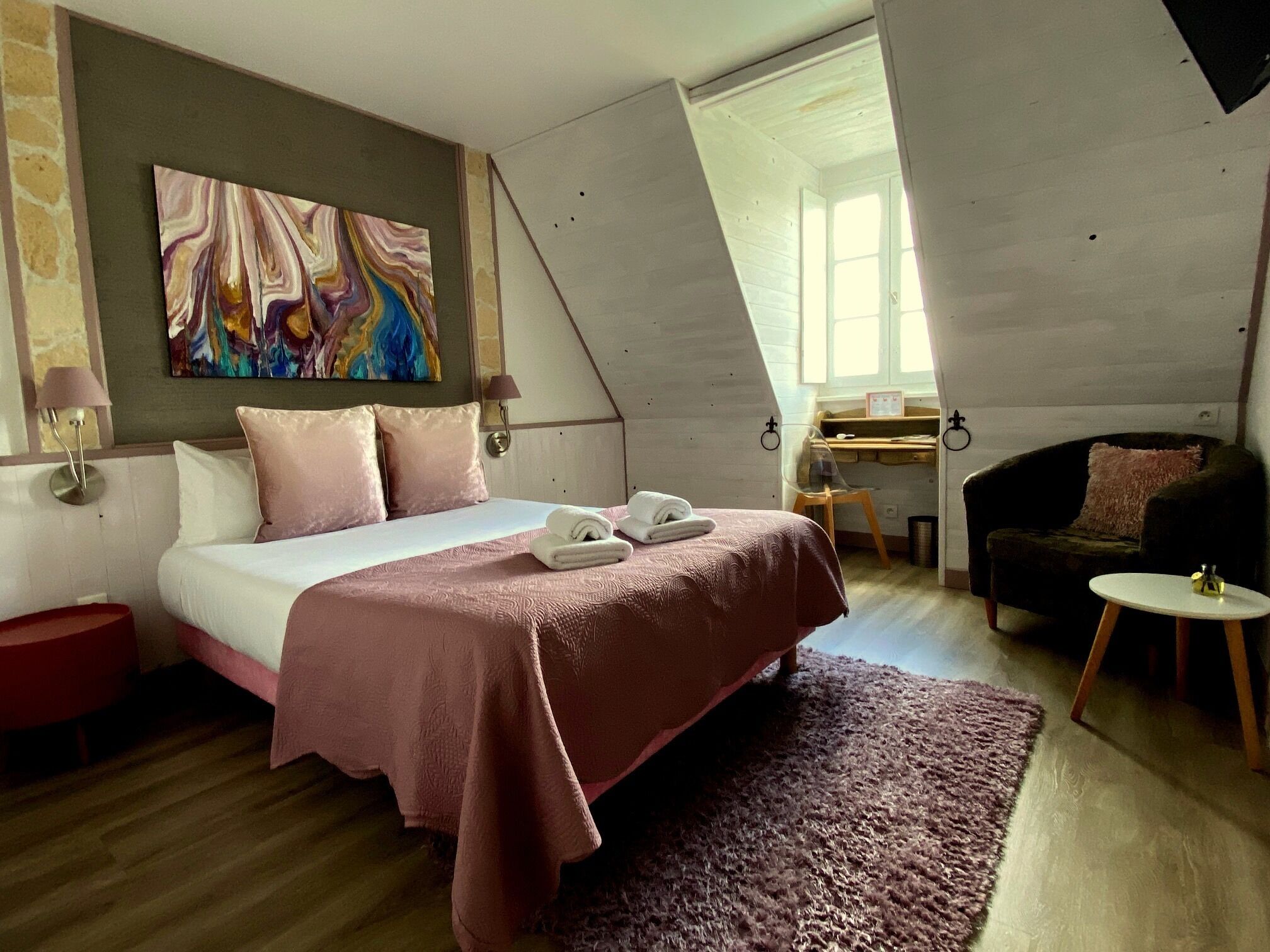 Een slaapkamer met een bed, een bureau en een stoel.