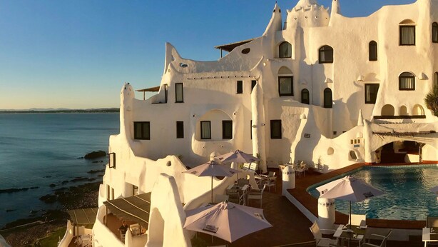 Un edificio blanco con piscina y zona de estar al aire libre.