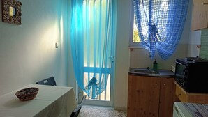 Una cocina compacta con comedor, un lavamanos, un microondas y una estufa.