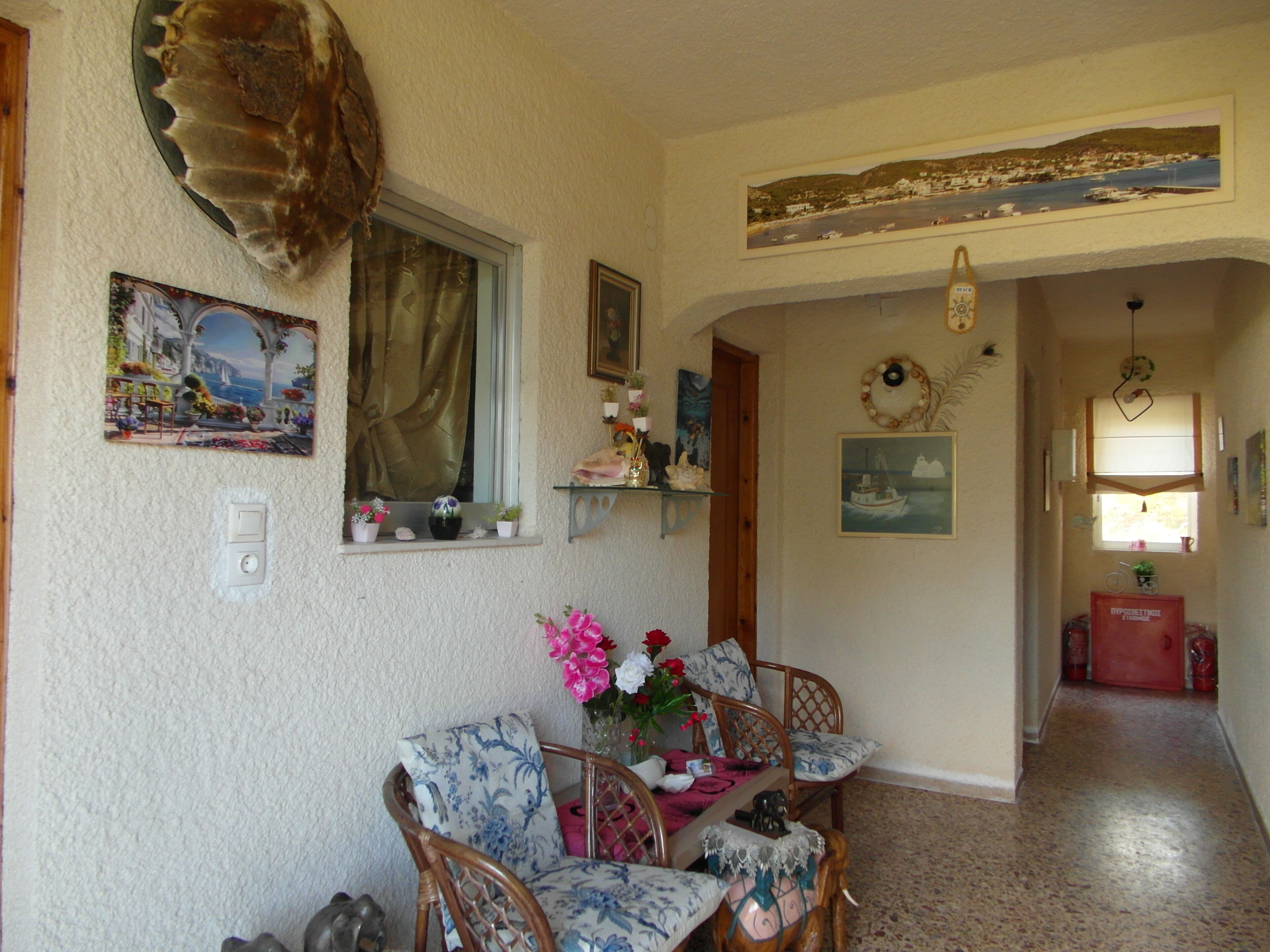 A cozy living room with a dining area, a large window, and a hallway leading to another room.