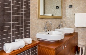 A bathroom with two sinks, a mirror, and a towel rack.