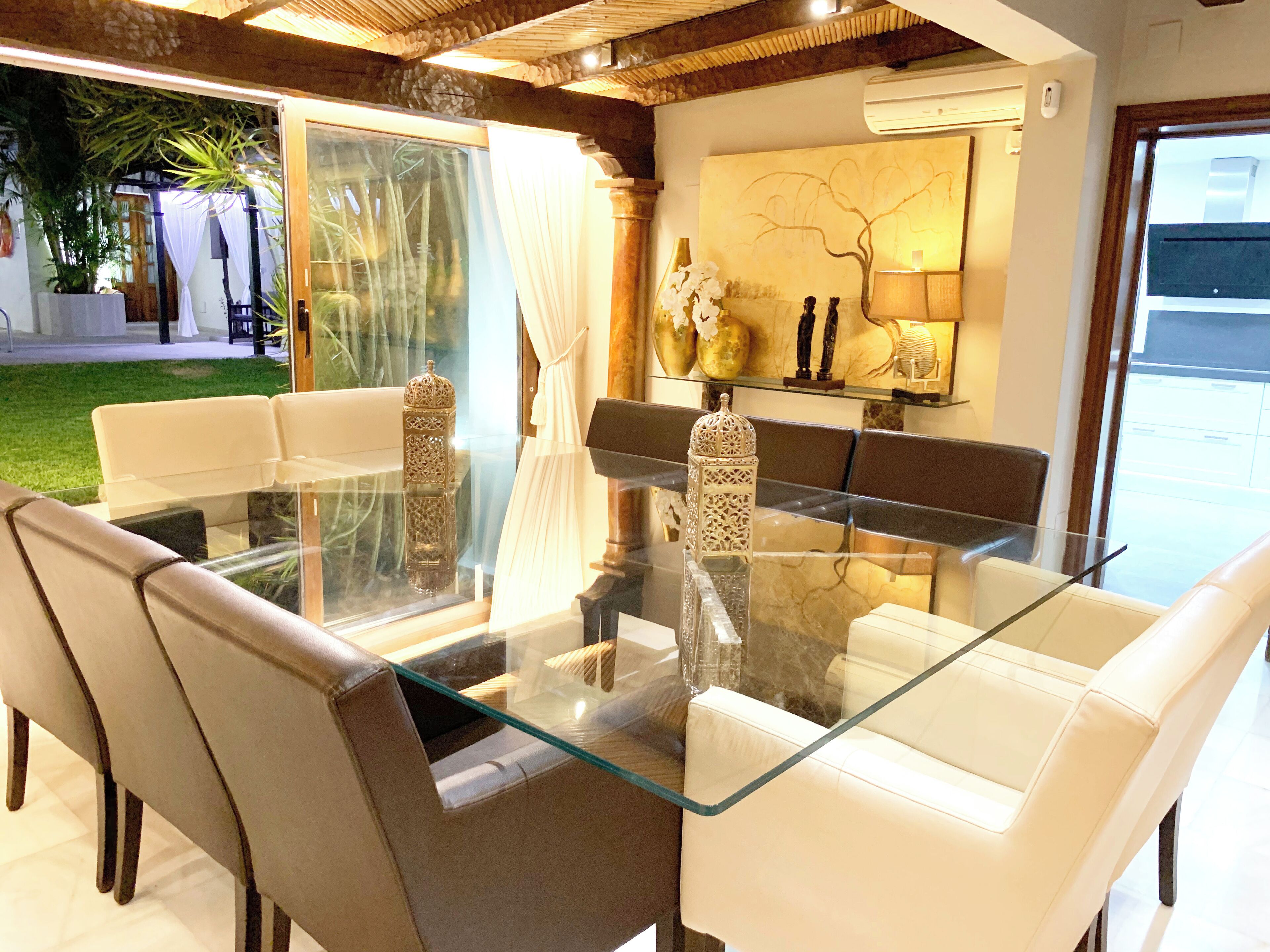 Un espace repas moderne avec une table en verre entourée de chaises en cuir.