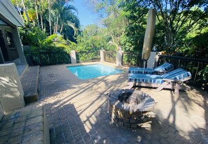 A backyard with a swimming pool, lounge chairs, and a barbecue grill. - Pelican s Nest Holiday Home St Lucia (St. Lucia)