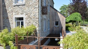 A stone building with a wooden staircase and metal railings. - Holiday Home in Gedinne by the River (Vencimont)