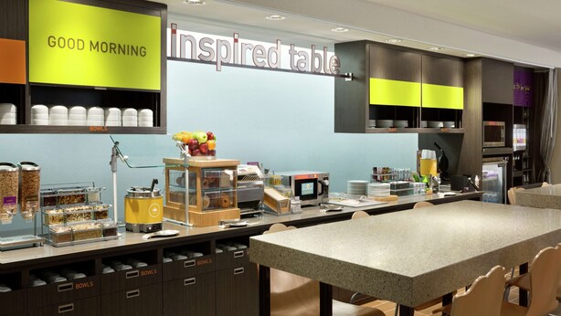 A breakfast area with a sign reading "GOOD MORNING" and "inspired table". - Home2 Suites by Hilton McAllen (McAllen)