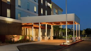 A modern hotel with a covered outdoor area, multiple floors, and a sign indicating it is a Home2 hotel. - Home2 Suites by Hilton McAllen (McAllen)