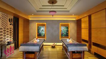Relax in a serene spa room with two massage tables, a soothing ambiance, and beautiful artwork.