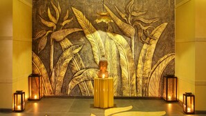 A room with a Buddha statue on a pedestal, surrounded by candles and a decorative wall. - Radisson Blu Jammu (Jammu)