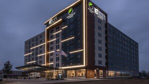 A modern hotel with a prominent logo, multiple floors, and a well-lit entrance. - Element by Marriott Dallas Love Field (Dallas)